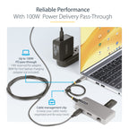 Laptop with USB-C hub, power adapter, and cable management clip on a white background.