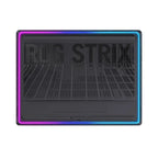 A black rectangular gaming accessory with a ribbed textured surface and the words 'ROG STRIX' printed across the top, framed by a glowing RGB LED border that shifts through purple, blue, and cyan on a white background.