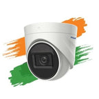 A white dome security camera with a black lens surround, shown against a white background with orange and green paint strokes resembling the Indian flag. The brand name 'PRAMIAR' is visible on the side of the camera.