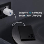 A black portable power bank with a white cable plugged into a white USB charger, shown on a dark surface with text that says it supports Samsung super fast charging.