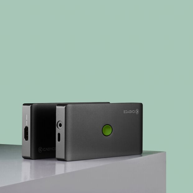 Two portable power banks, one matte black and one dark gray, displayed on a light gray surface against a solid mint green background. The front power bank is in focus, showing a glowing green LED indicator light and the white 'ECOSKY' brand logo.