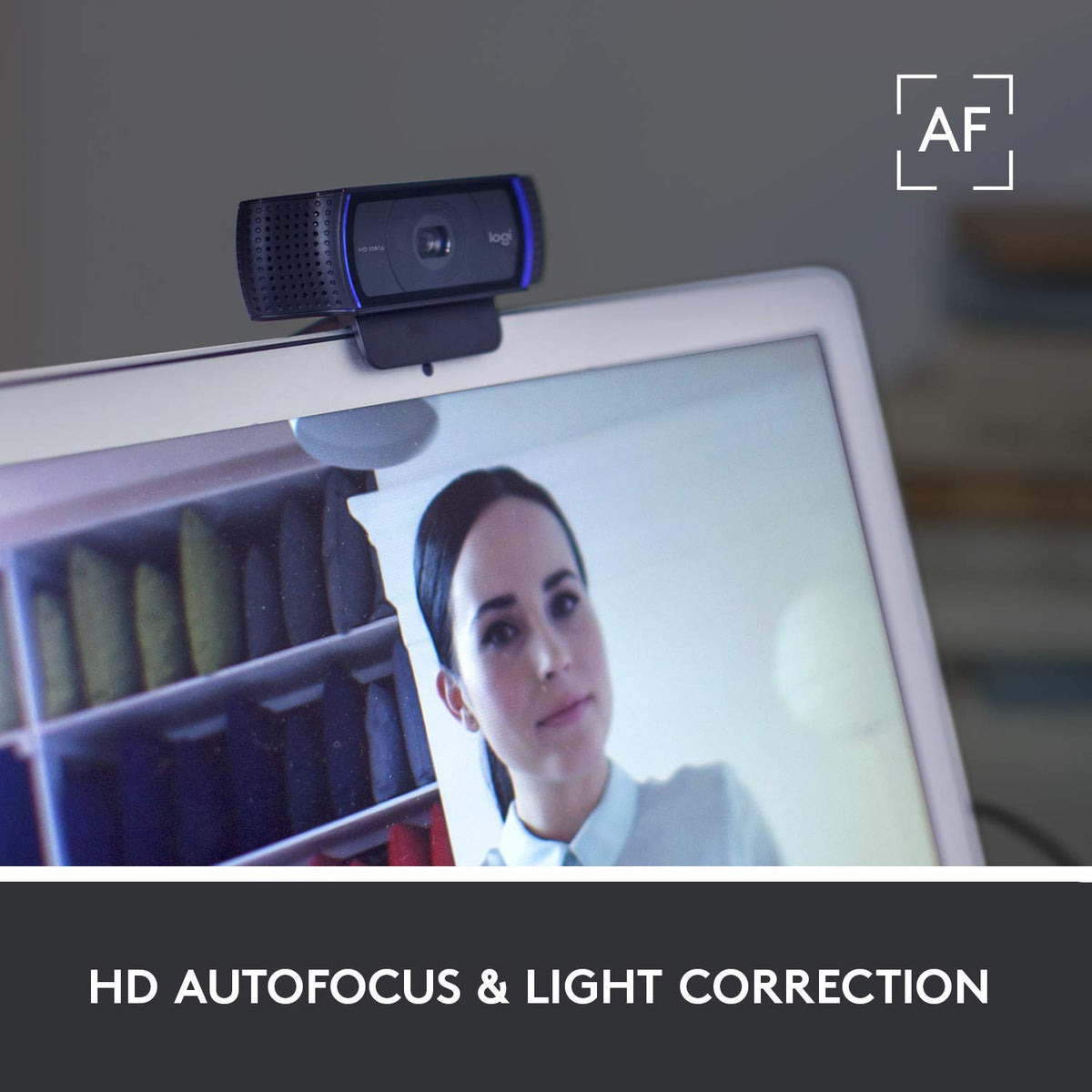 Webcam on a laptop screen with a person's face displayed, set against a blurred bookshelf background.