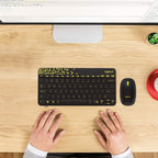 Logitech keyboard and mouse set on a wooden desk with a computer monitor in the background.