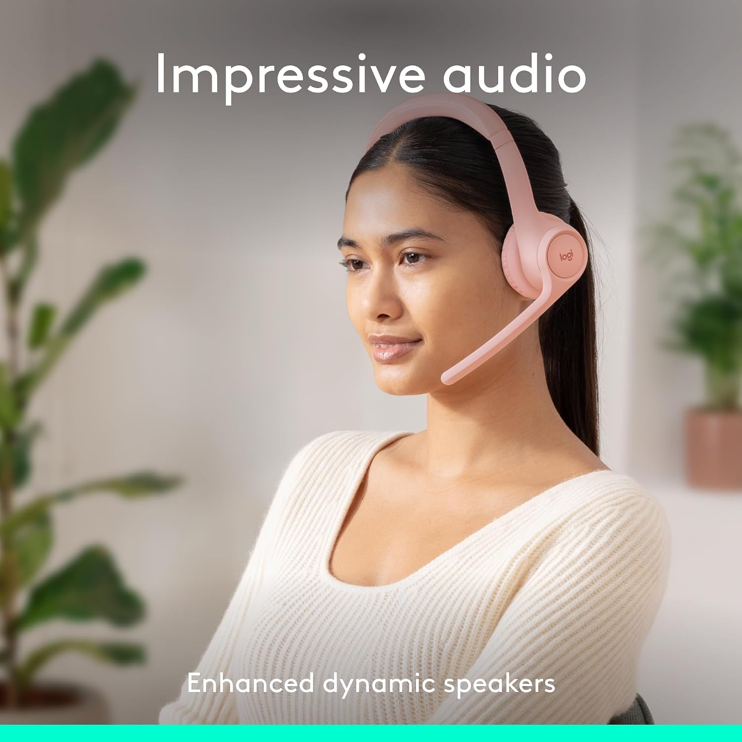 Woman wearing pink headphones with text 'Impressive audio' and 'Enhanced dynamic speakers' on a blurred indoor background.