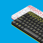 Two keyboards, one white and red, the other black with yellow letters, on a blue background.