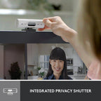 Person holding a small device over a screen displaying a woman in a kitchen.