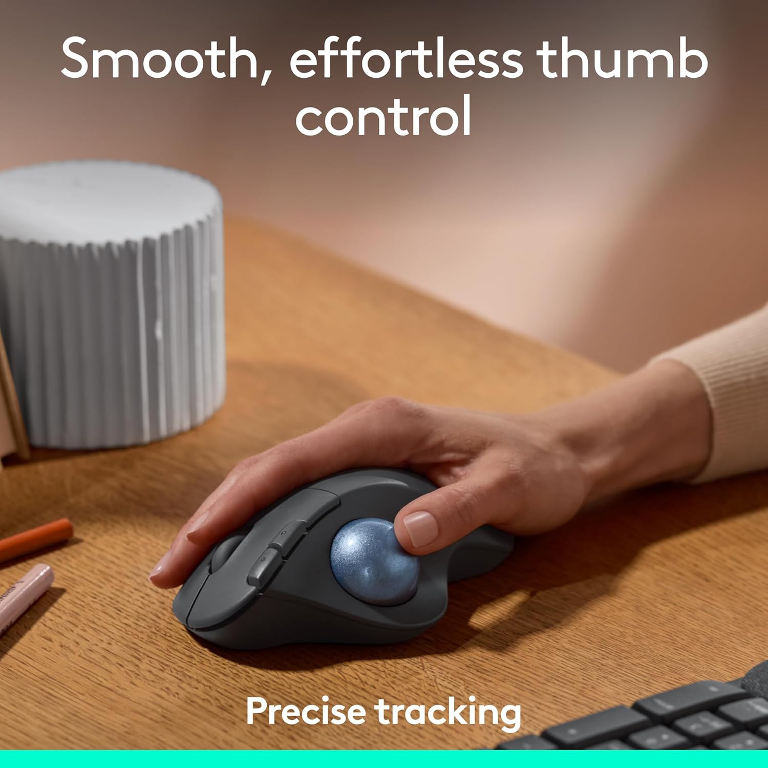 Hand using a trackball mouse on a desk with text about smooth thumb control and precise tracking.