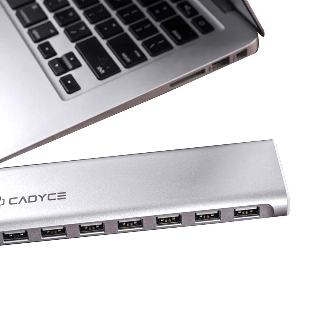 A silver aluminum 7-port USB hub with the brand name CADYCE printed on the side, shown next to a laptop keyboard on a white background.
