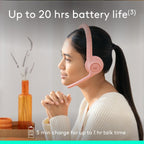 Woman wearing pink headphones with text about battery life on a blurred indoor background