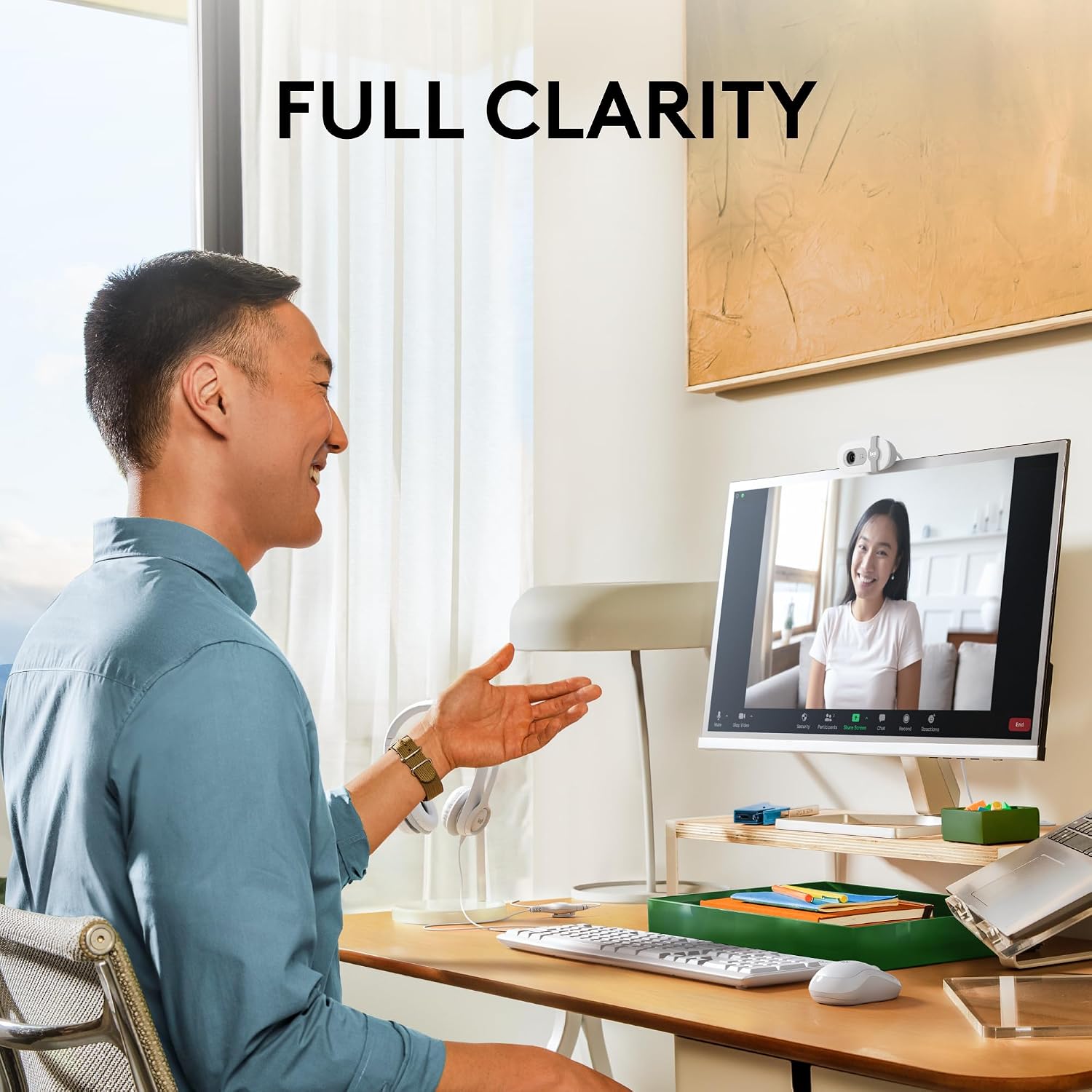Man in a home office setting with a computer screen displaying a video call.