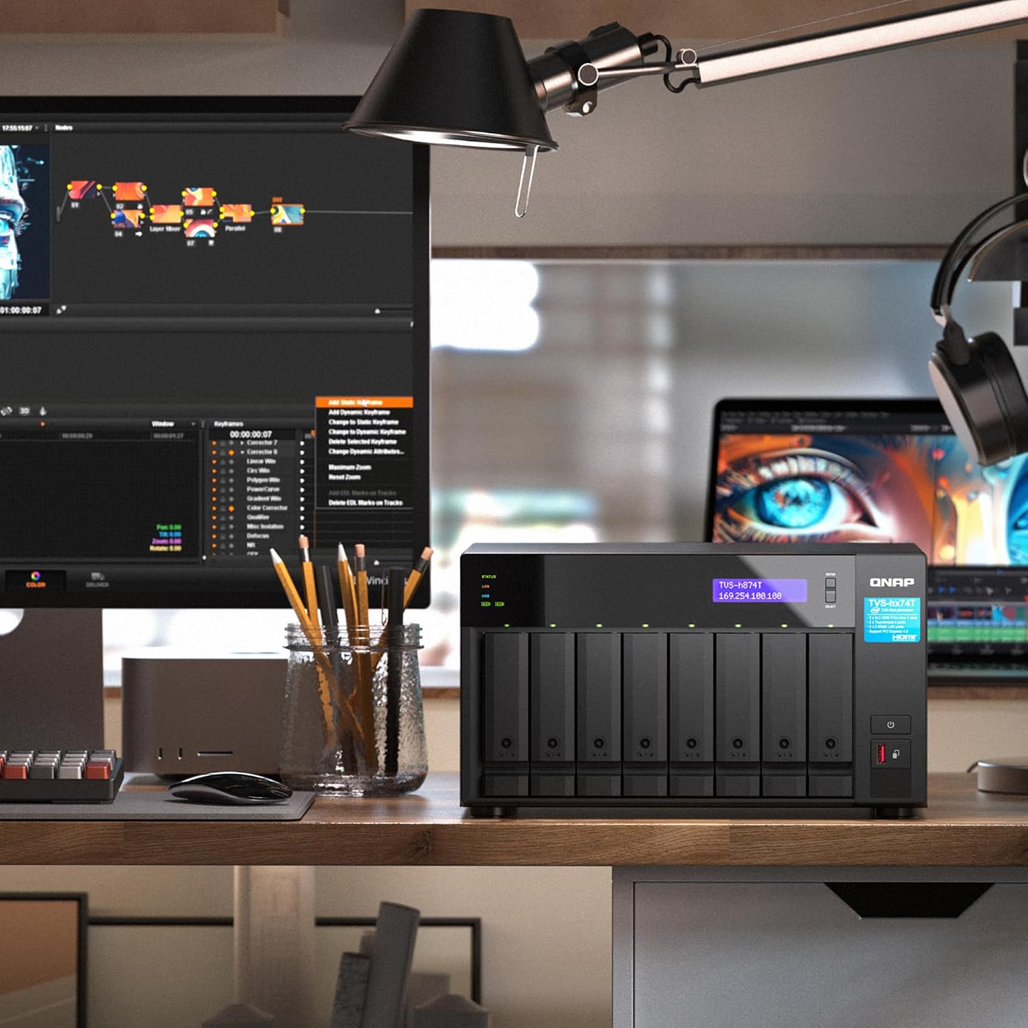 Studio setup with multiple monitors, a laptop, and a large hard drive on a desk.