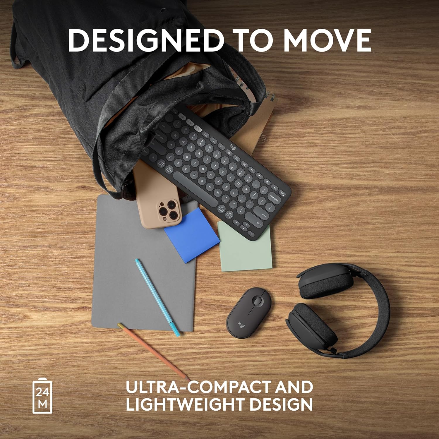 A black ultra-compact keyboard shown spilling out of a black bag on a wooden desk, with a phone, mouse, headphones, sticky notes, and pencils around it. Text reads 'DESIGNED TO MOVE' and 'ULTRA-COMPACT AND LIGHTWEIGHT DESIGN'.