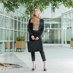 Woman holding a black briefcase in an office building courtyard