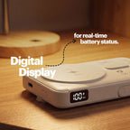 A portable power bank with a digital display showing 100% battery status, placed on a wooden table with text overlays highlighting its digital display feature.