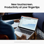 A person seated at a table uses a silver laptop in a home or office setting, pointing at a touchscreen display showing a dashboard with charts and graphs. Large text at the top reads, 'New touchscreen.