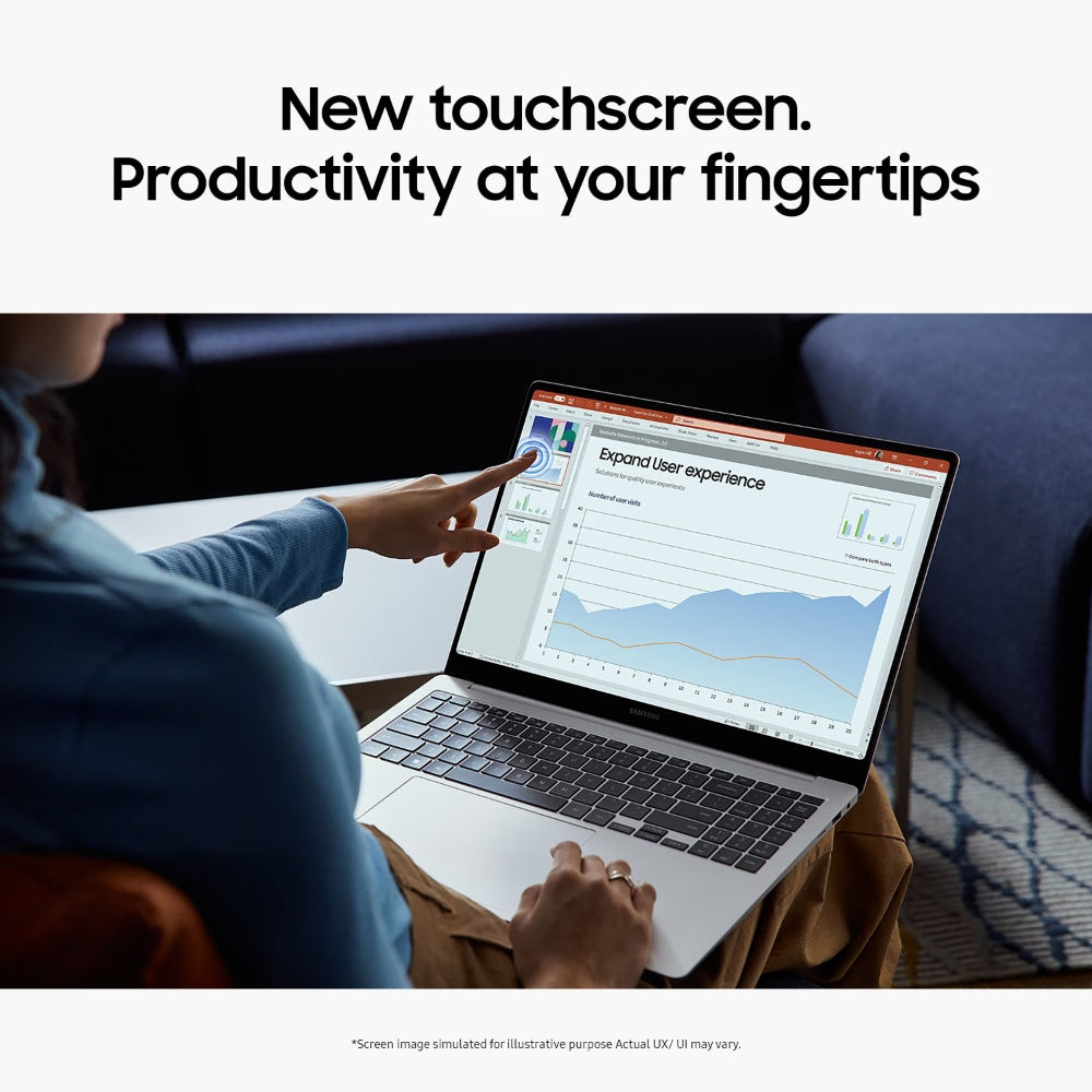 A person seated at a table uses a silver laptop in a home or office setting, pointing at a touchscreen display showing a dashboard with charts and graphs. Large text at the top reads, 'New touchscreen.