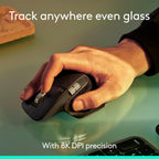 Hand using a computer mouse with text about 8K DPI precision on a green surface.