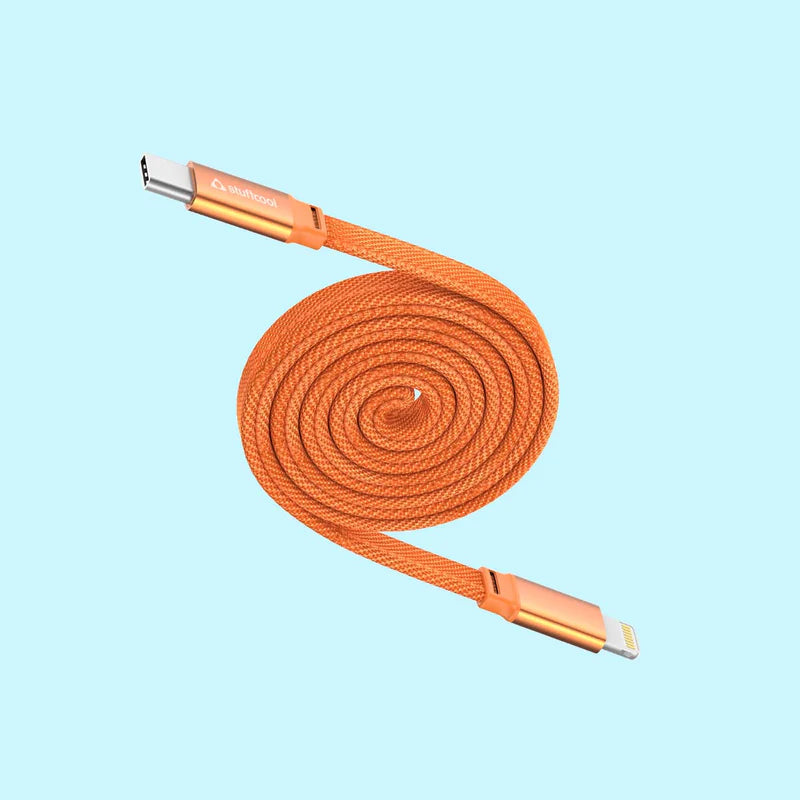 An orange braided USB-C to Lightning cable coiled in a spiral, featuring metallic gold-toned connector housings on a light blue background.