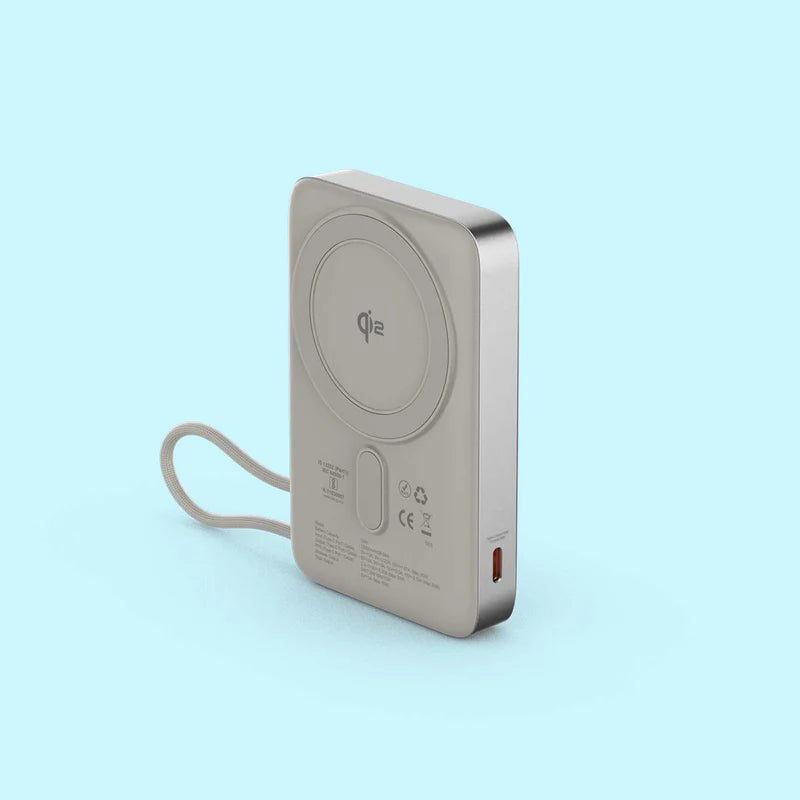 A silver portable power bank with a built-in wrist strap, featuring a Qi wireless charging pad on the back and a USB-C port on the side, set against a solid light blue background.