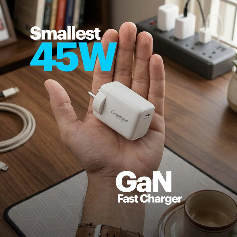 Hand holding a small 45W GaN fast charger with visible brand logo on a desk background.