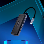 A black and silver USB-C hub with a ribbed top panel and a black USB-C cable, shown floating against a blue and black geometric background. The brand name 'Caviage' is printed on the side.