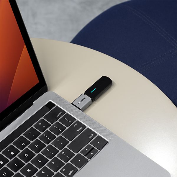 USB-C to USB 3.0 adapter plugged into a laptop USB-C port with blue LED