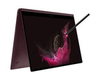 A Samsung convertible laptop shown open at an angle with the screen on, displaying a pink abstract wallpaper, and a stylus resting on the top right edge, against a plain white background.