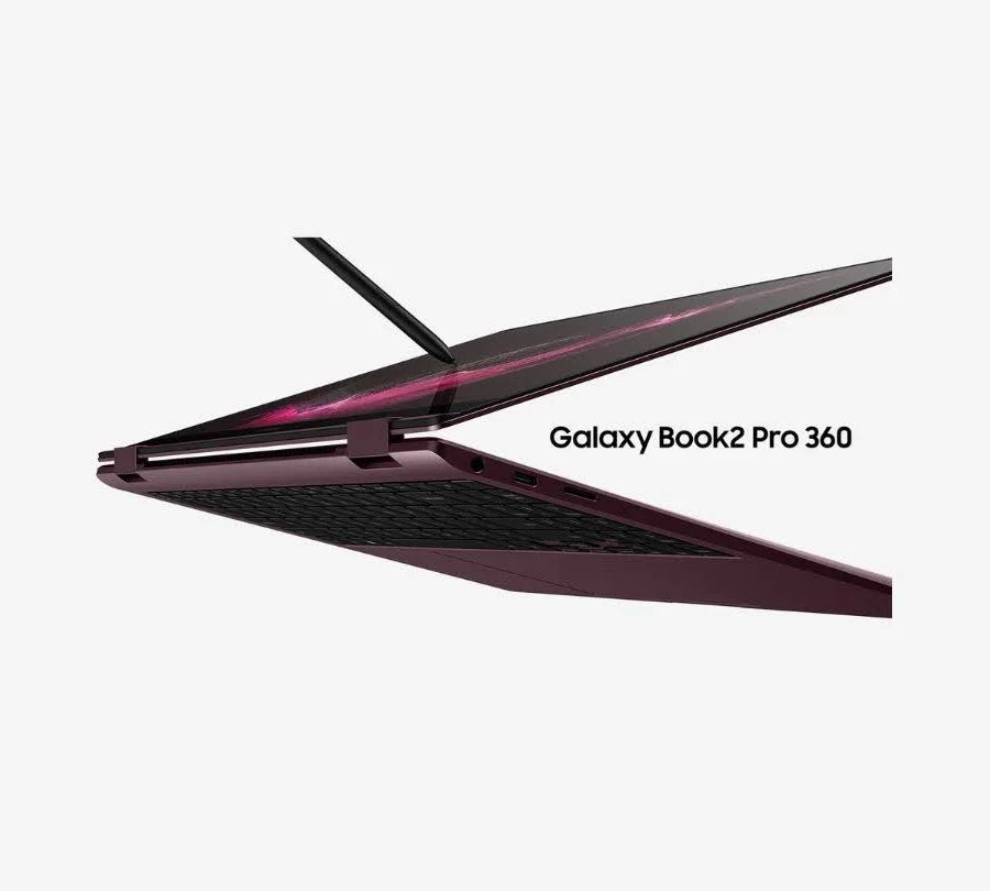 A Galaxy Book2 Pro 360 laptop shown open at an angle against a light gray background, with a dark metallic finish and pink accent lighting along the screen edge.