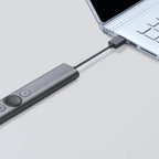 USB-C adapter connected to a laptop on a light gray background