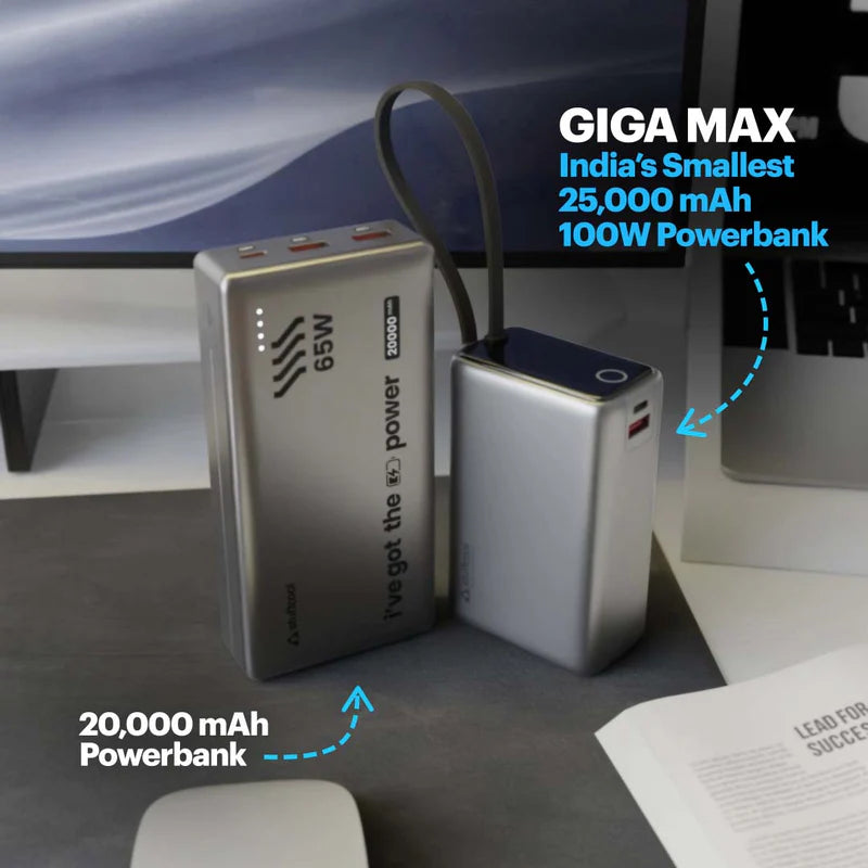 Two portable power banks displayed on a desk in front of a computer monitor, with promotional text overlays highlighting their 20,000 mAh capacity and 65W/100W power output.